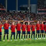 Espanjan maajoukkue punaisissa paidoissa kentällä valmiina ottelun aloitukseen