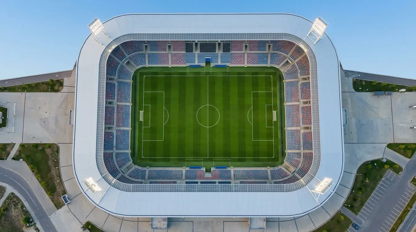 Tyhjä jalkapallostadion ylhäältä kuvattuna, kenttä valmiina otteluun, kirkkaat valot
